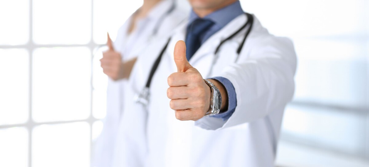 Group of doctors showing thumbs up. Perfect medical service in clinic. Happy future in medicine and healthcare concept